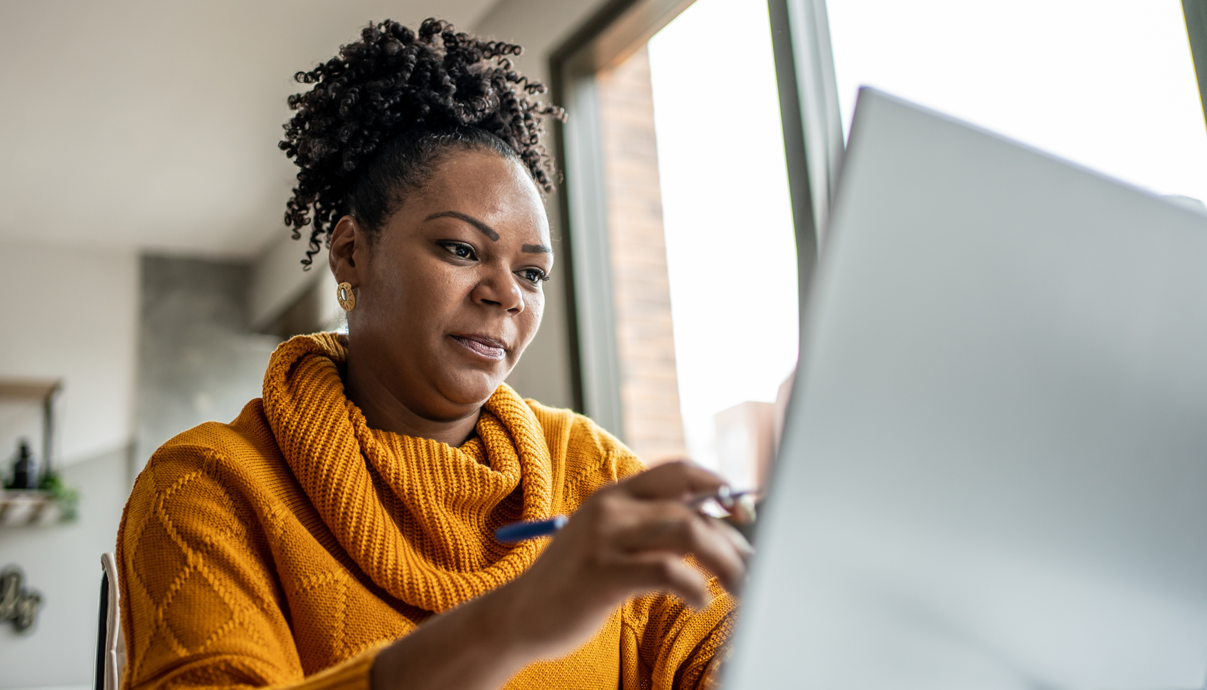 A photo of a black woman using a computer to access the Breaking Free program.